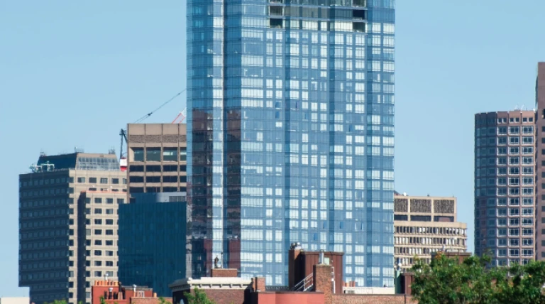 modern-skyscraper-with-glass-facade-greenery-around.webp